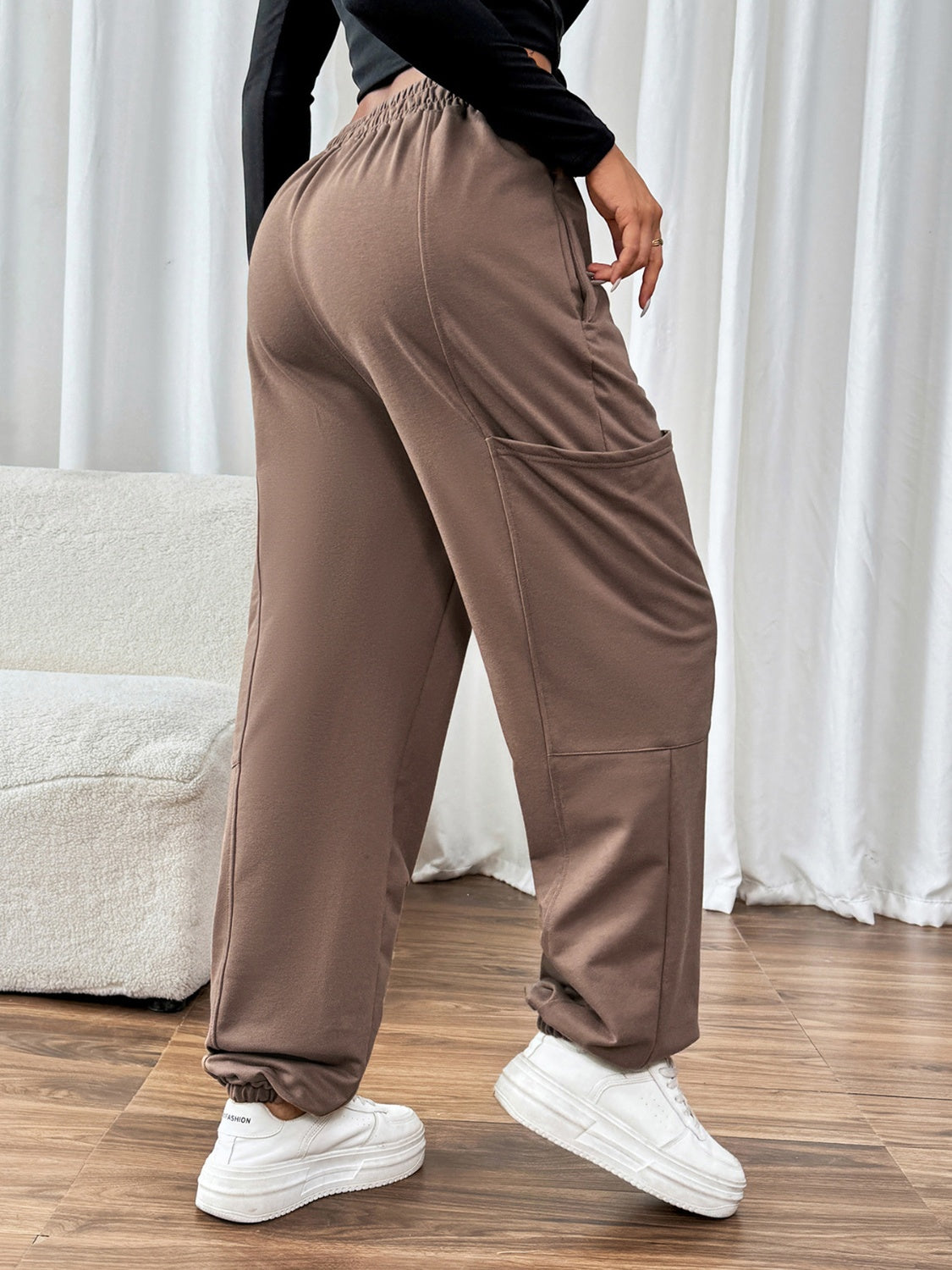 Taupe cargo joggers with elastic waistband and cuffs, and large side pockets.
