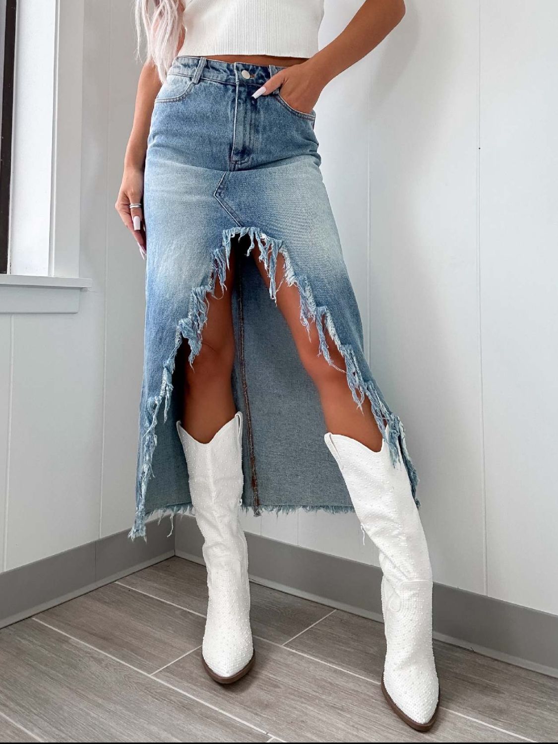 Distressed denim maxi skirt in light wash with a high slit and frayed hem.
