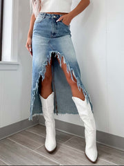Distressed denim maxi skirt in light wash with a high slit and frayed hem.
