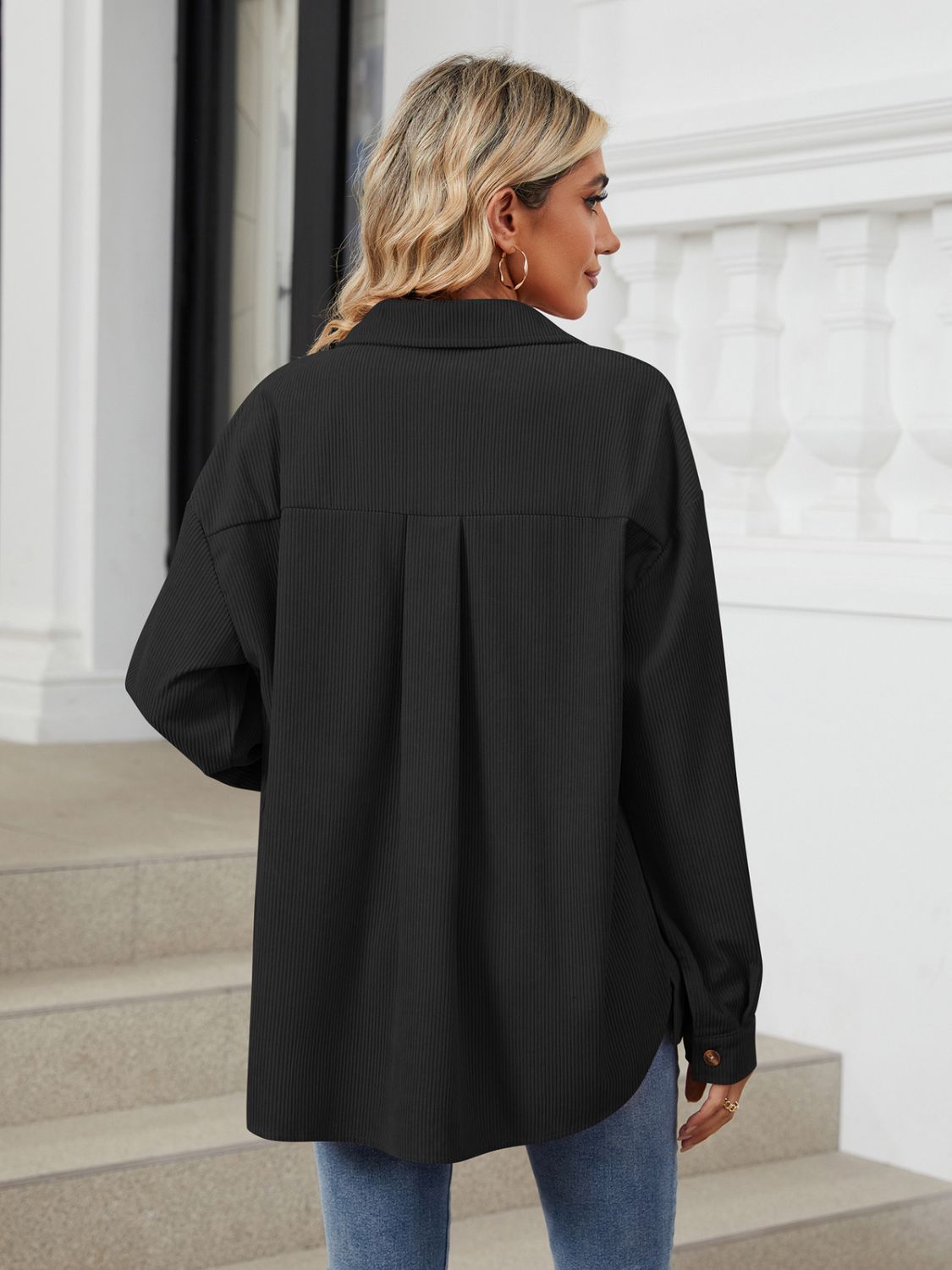 Black corduroy overshirt with buttoned cuffs and back pleat detail.