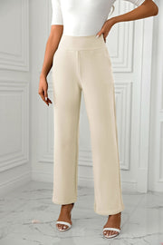 Beige wide-leg trousers with a sculpted waist, shown on a model.