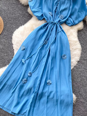 Blue floral maxi dress with puff sleeves, tie waist and button front.