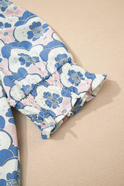 Blouse with blue and pink floral print, smocked cuffs, and frill detail.