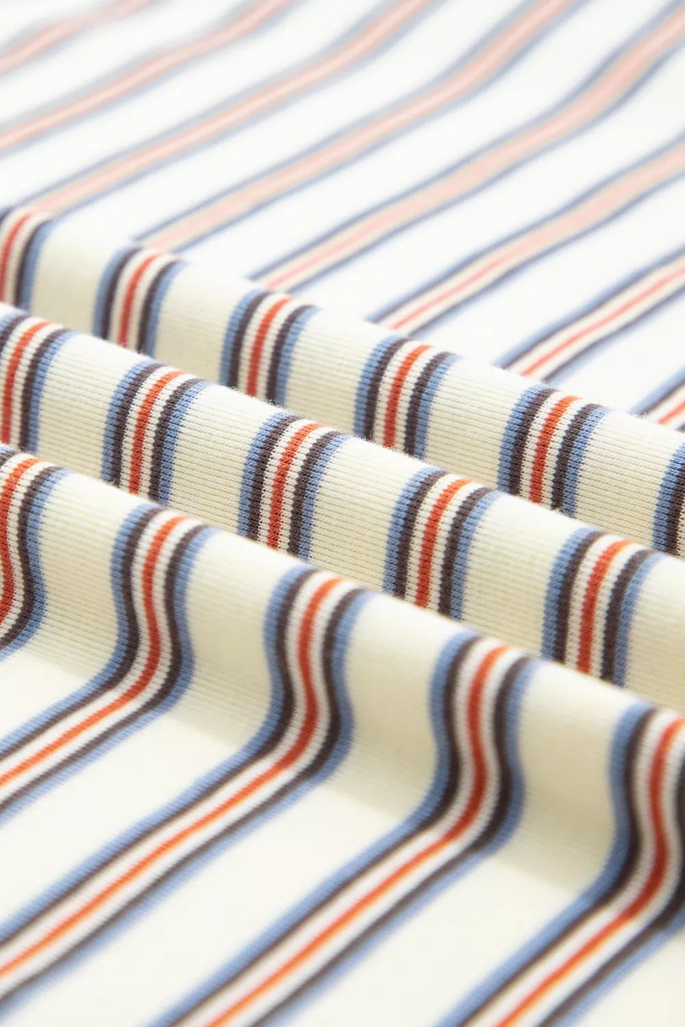 Cotton striped mini dress with blue, orange, and brown stripes on a cream background.