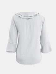 White linen blouse with ruffled neckline and flared 3/4 sleeves.