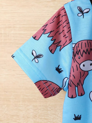 Baby pajama set with highland cow print on blue fabric, short sleeves.
