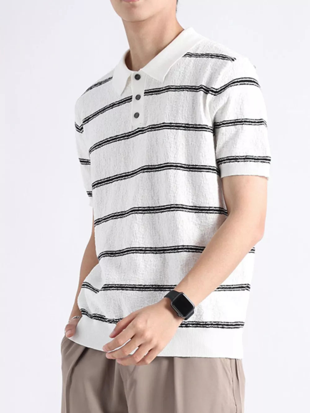 White knit polo with black horizontal stripes, button accents, and textured fabric.