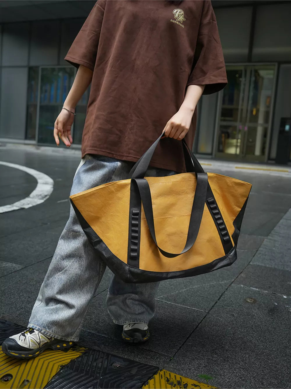 Yellow and black two-tone large capacity travel bag with black straps and handles.