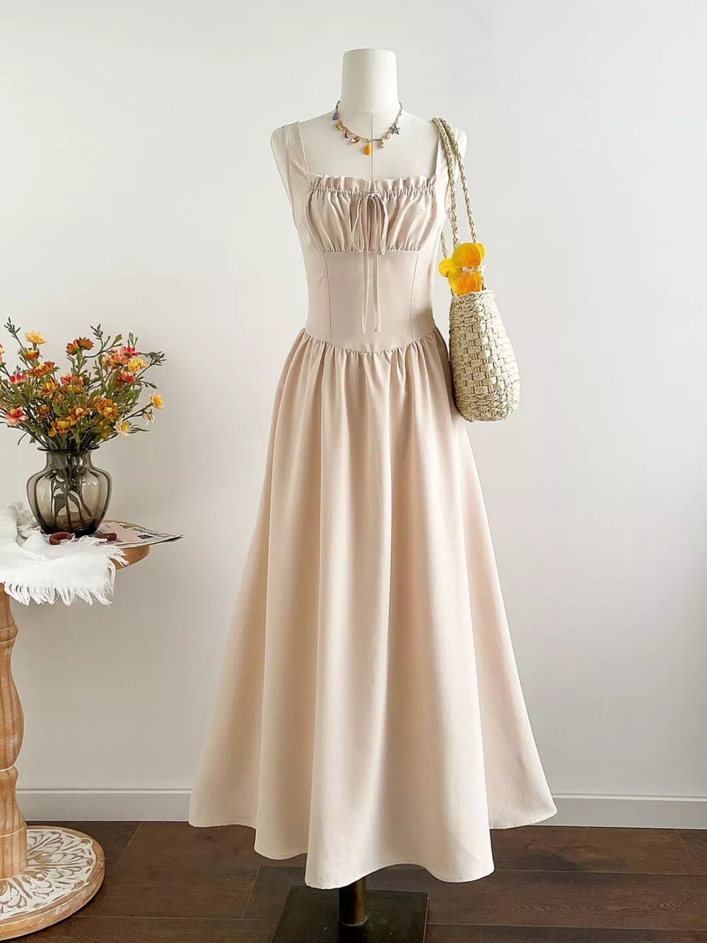 Elegant cream square neck a-line maxi dress with drawstring bust and spaghetti straps.