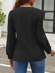 Black perforated puff sleeve blouse with textured fabric and balloon sleeves.