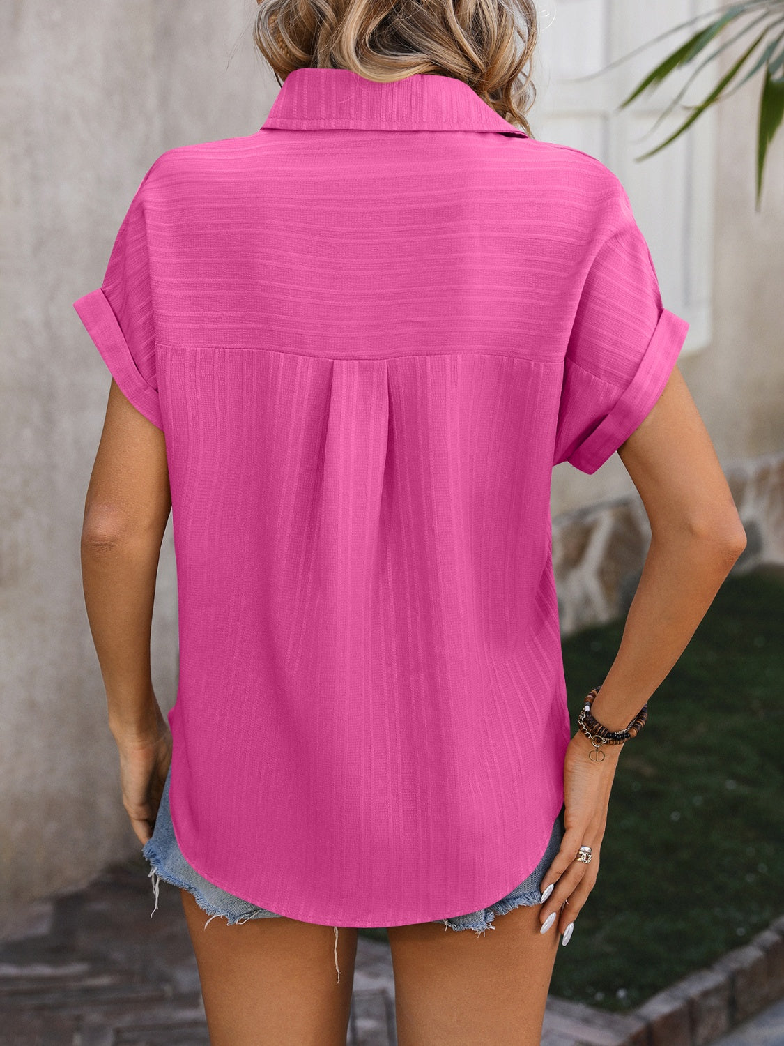 Pink textured button-down shirt with cuffed short sleeves and a relaxed fit.