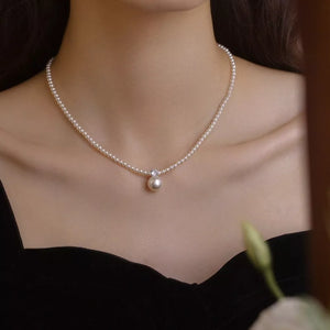 Luminous pearl pendant choker necklace with a single pearl drop and crystal accent.