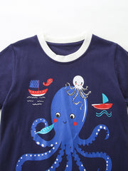 Navy cotton baby t-shirt with playful octopus and sailboat graphic, white trim neckline.