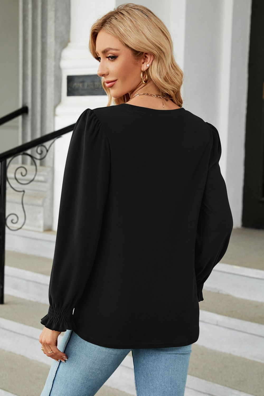 Black ribbed cuff top with puff sleeves and ruffled cuffs.