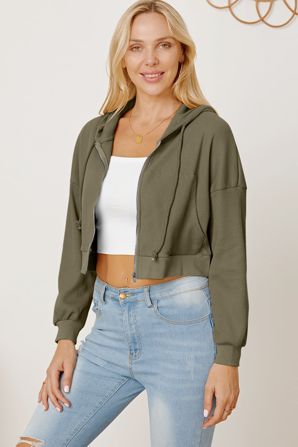 Army green waffle knit cropped zip hoodie with drawstring hood and elastic cuffs.