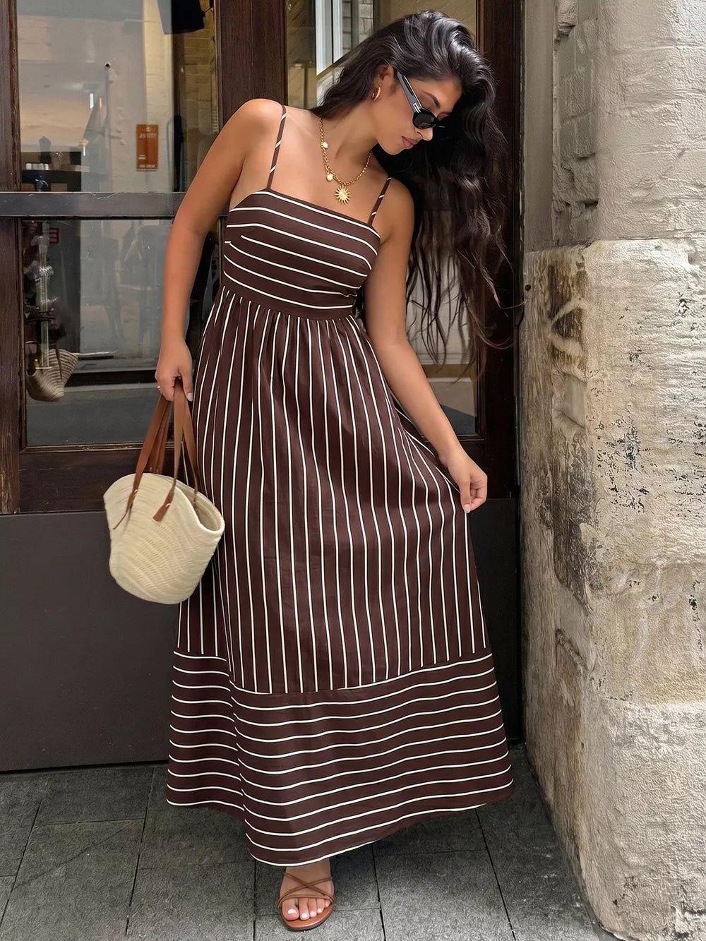 Brown striped maxi dress with smocked detail and cutout, spaghetti straps.