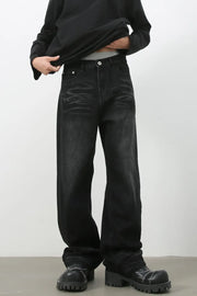 Faded black baggy denim trousers with a relaxed fit and visible distressing.