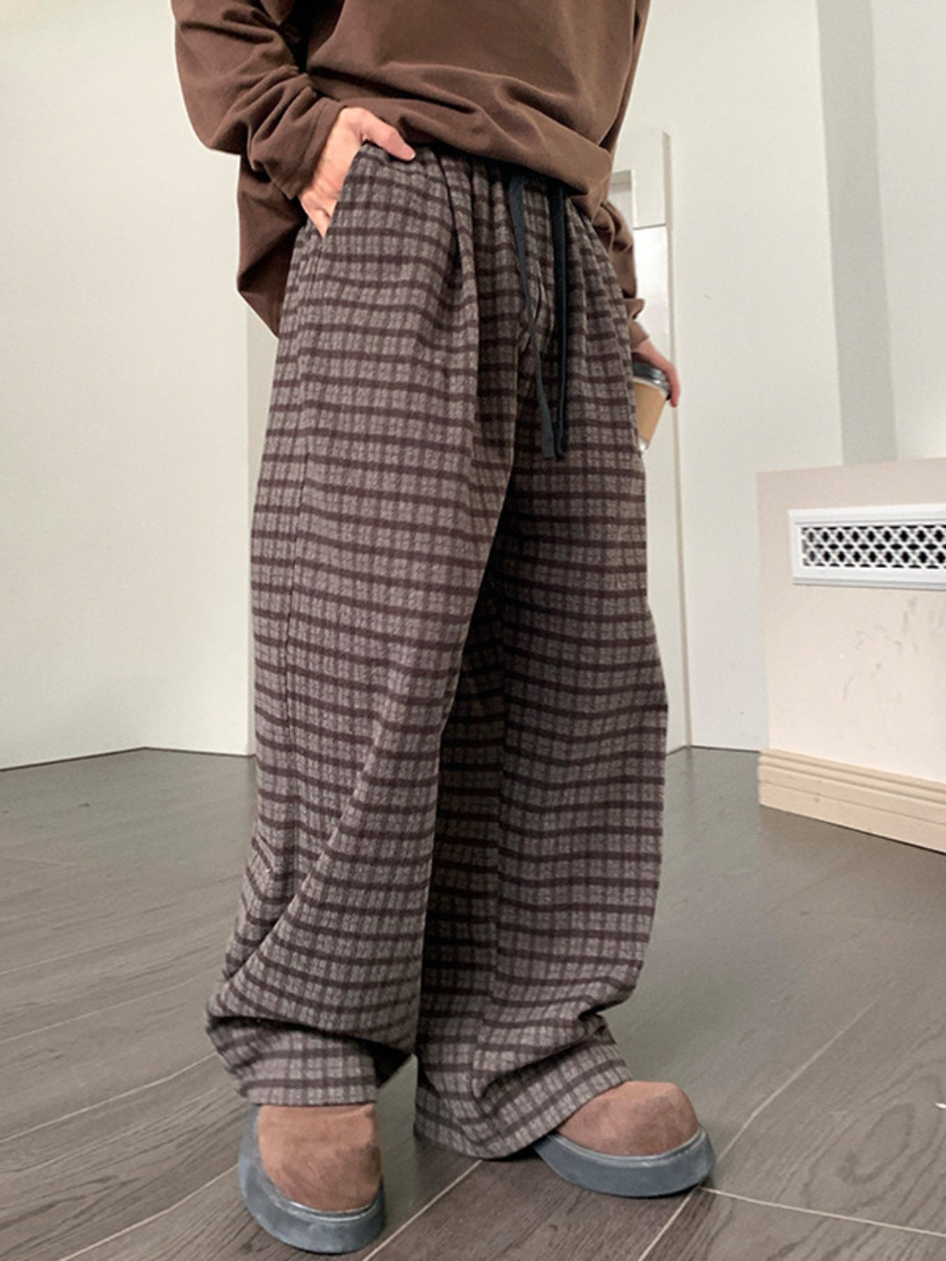 Men's brown plaid wide leg trousers with drawstring waist.