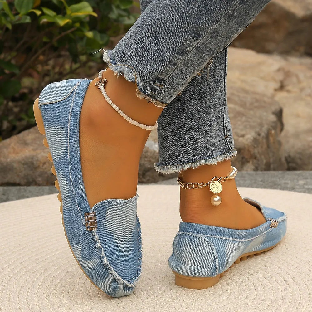 Light denim loafers with stitch detail and metal accent.