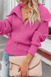Hot pink ribbed knit cardigan with shawl collar and zip front closure, styled with jeans and a clutch.