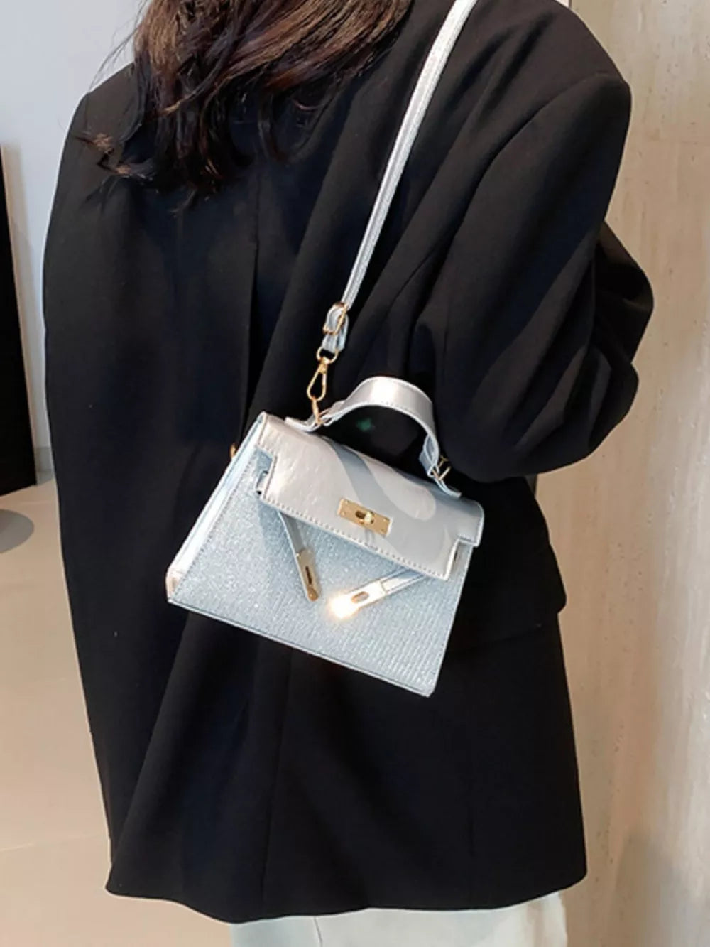 Silver glitter textured mini crossbody bag with gold hardware and turn-lock closure.