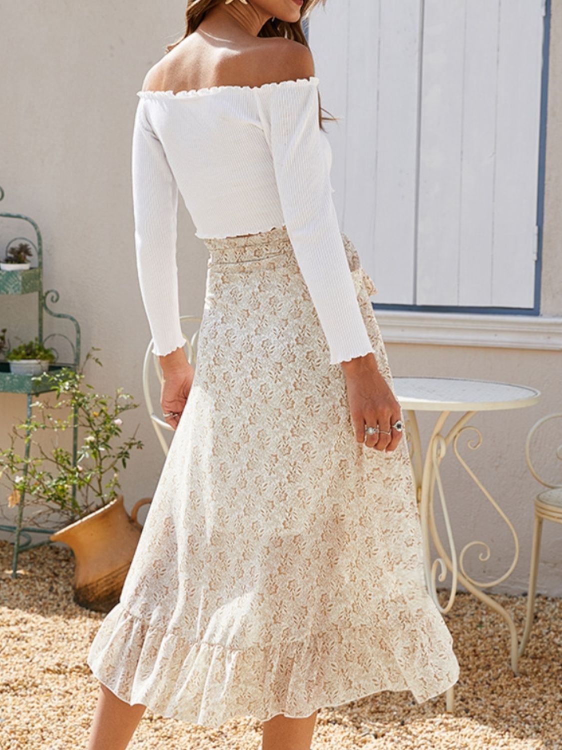 Asymmetric wrap skirt in cream with a delicate leaf print and ruffled hem.