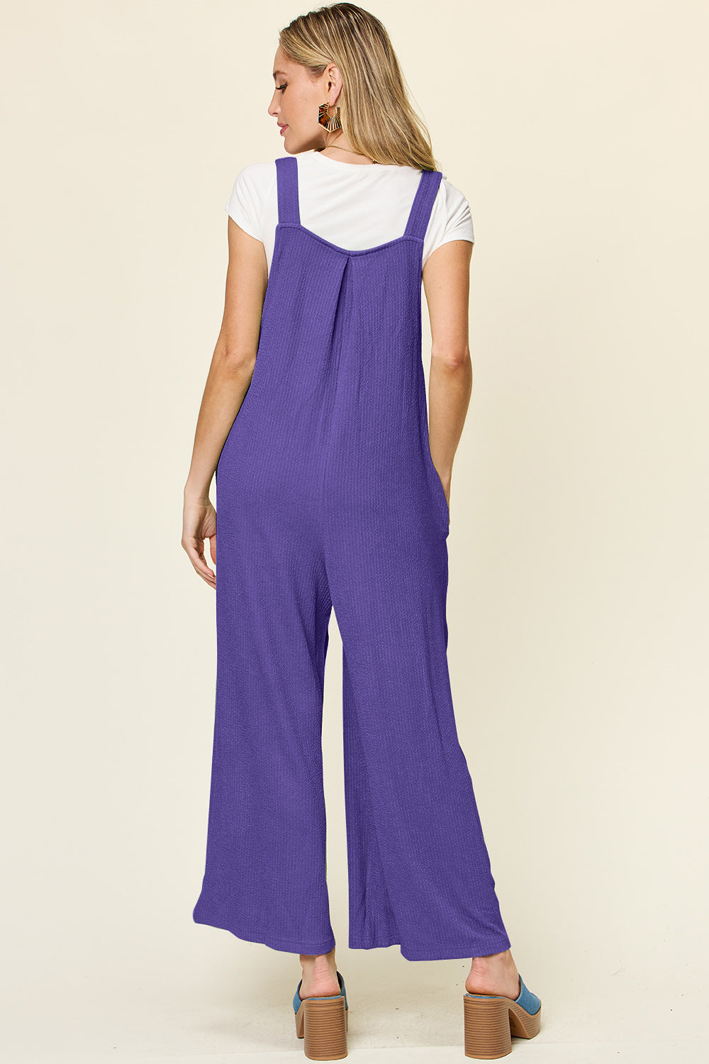 Ribbed wide-leg pinafore jumpsuit in royal blue with pleats and pockets.