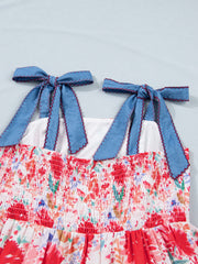 Floral print midi dress with smocked bodice and blue tie-shoulder straps.