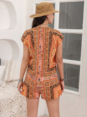Bohemian print cap-sleeve playsuit in orange with detailed patterns, featuring a V-neck and short sleeves.