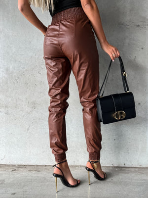 Brown leatherette gathered waist joggers with elastic cuffs and cinched ankles.