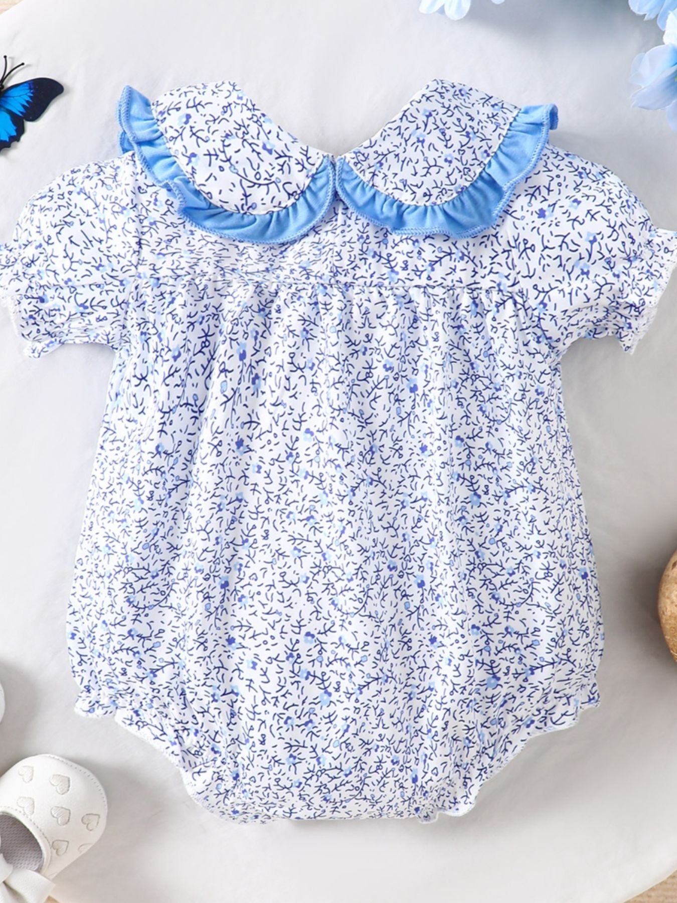 Baby one-piece with blue floral print, ruffled collar and short sleeves
