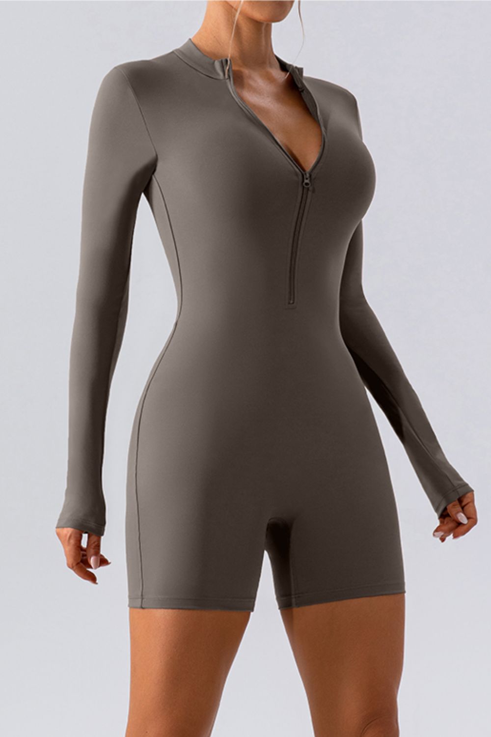Sculpted performance romper in dark gray with zip detail and long sleeves.
