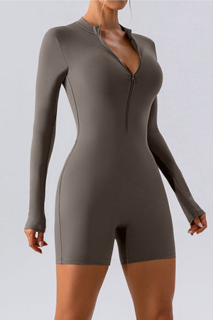 Sculpted performance romper in dark gray with zip detail and long sleeves.