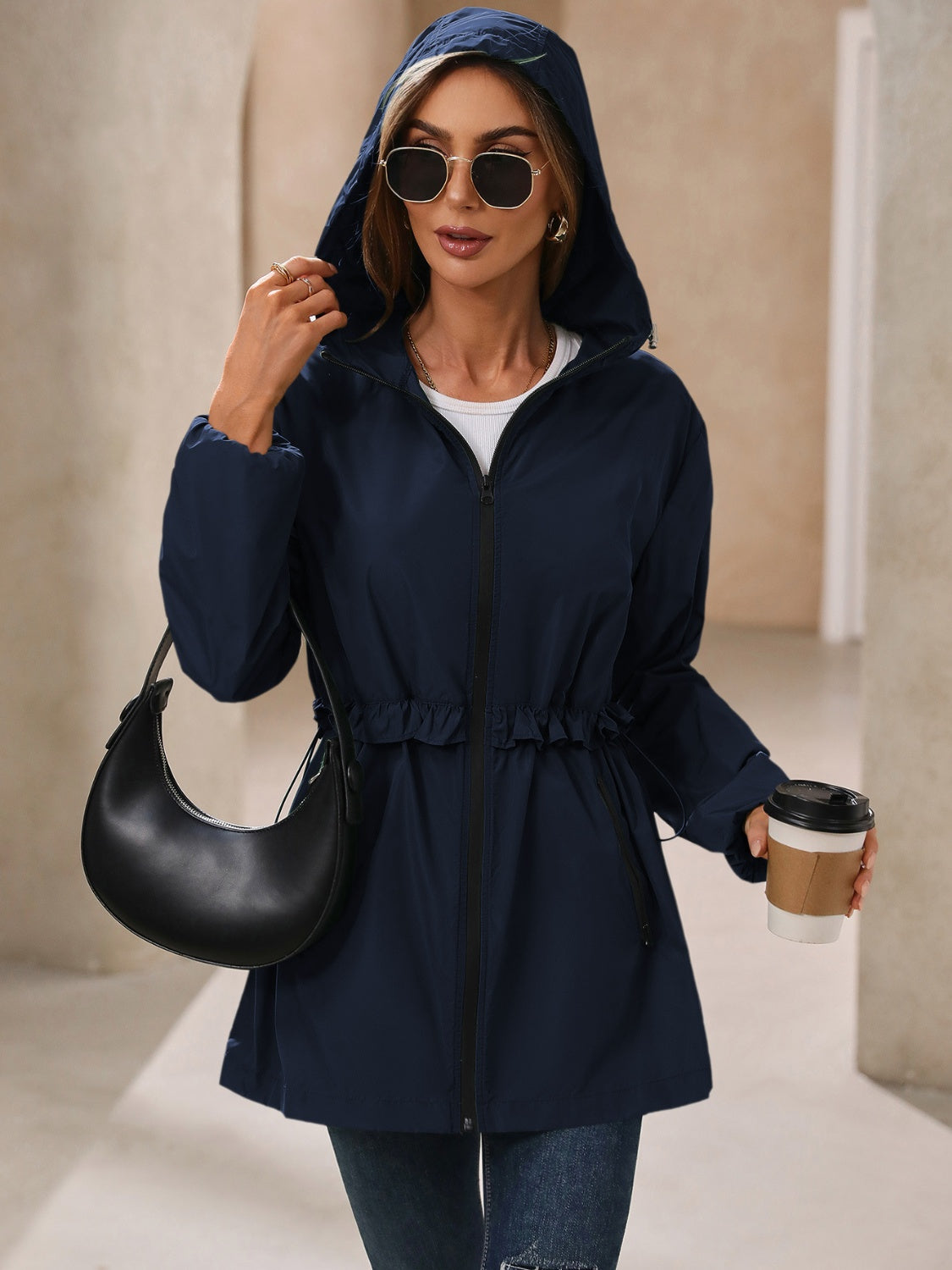 Navy hooded windbreaker jacket with ruffled drawstring waist and zippered front.