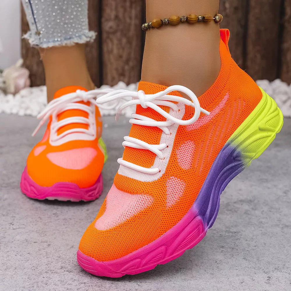 Orange red mesh lace-up sneakers with a pink, purple, and yellow gradient sole.