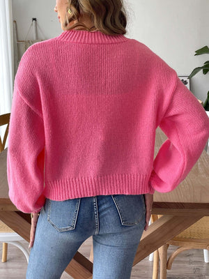 Bubble sleeve pink knit cardigan with pearl buttons and ribbed cuffs.