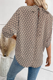 Blouse with geometric print, drape sleeves, and keyhole back tie detail.