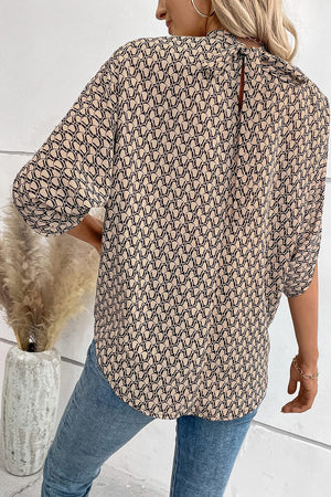 Blouse with geometric print, drape sleeves, and keyhole back tie detail.