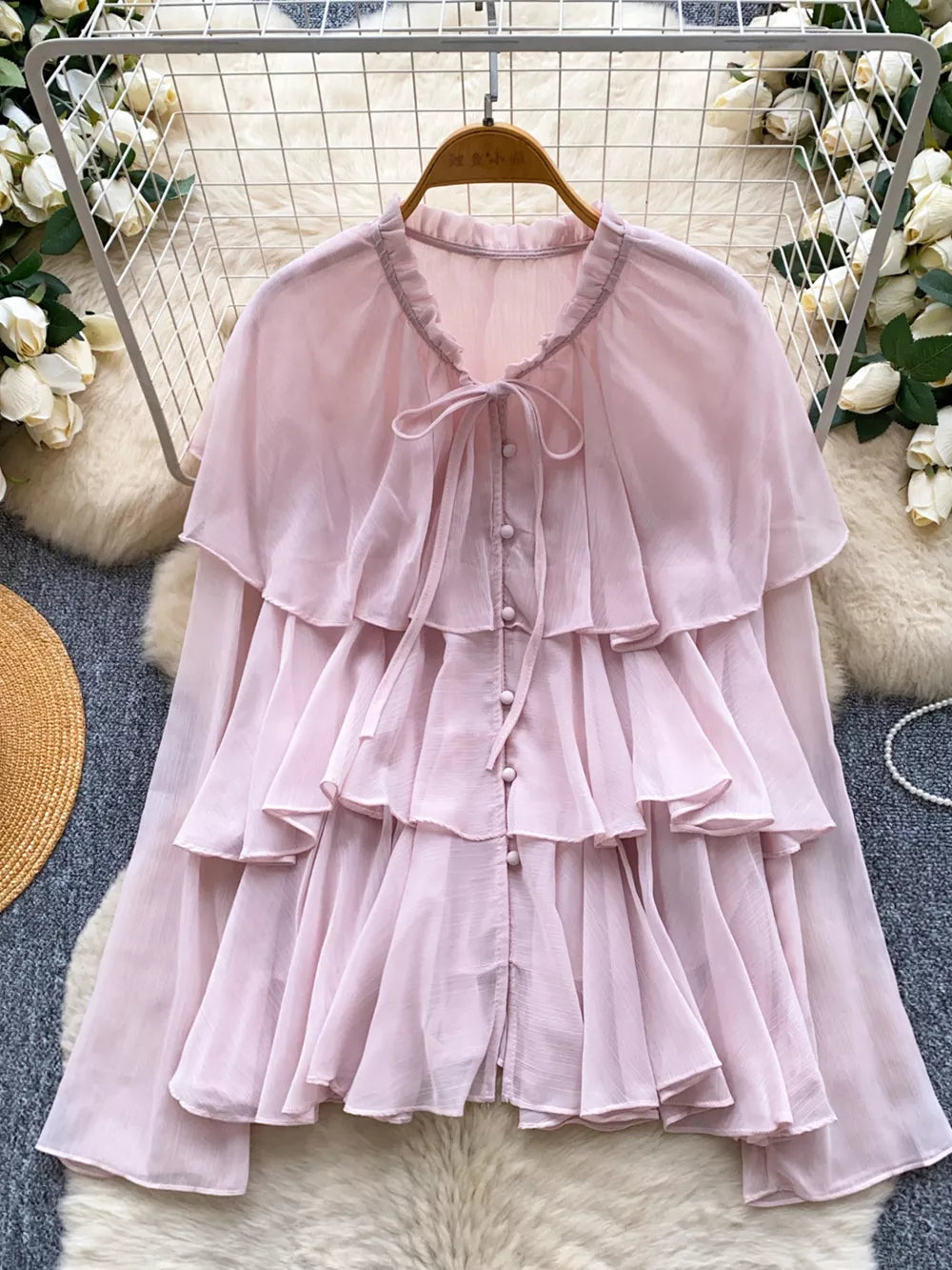 Pink chiffon blouse with tiered ruffles and bow tie neckline