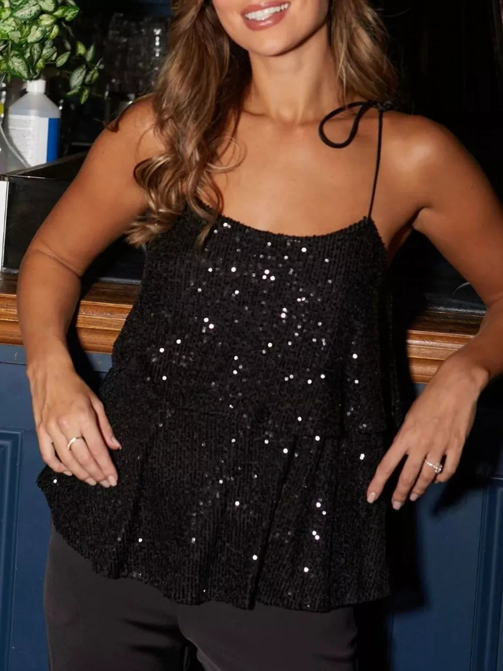 Black sequin tie-shoulder cami top with a tiered hem.