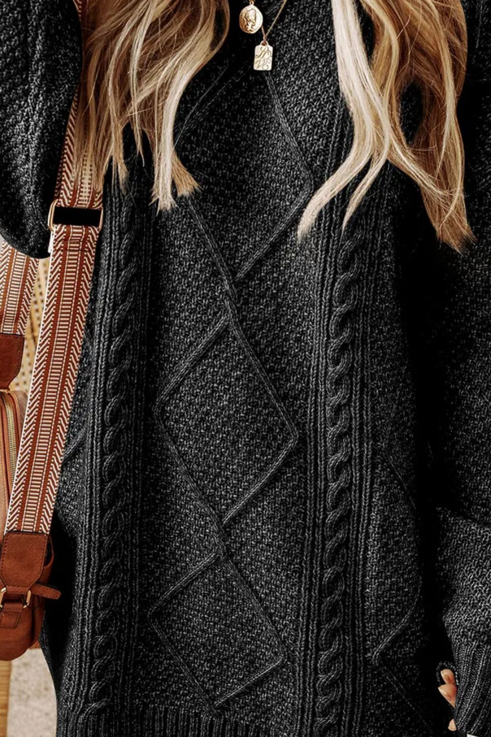 Black cable knit sweater dress with diamond pattern detail.