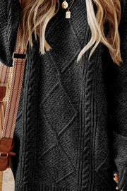 Black cable knit sweater dress with diamond pattern detail.