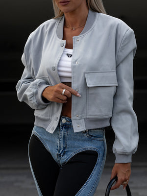 Boxy bomber jacket in light blue with snap front, ribbed cuffs, and two chest pockets.