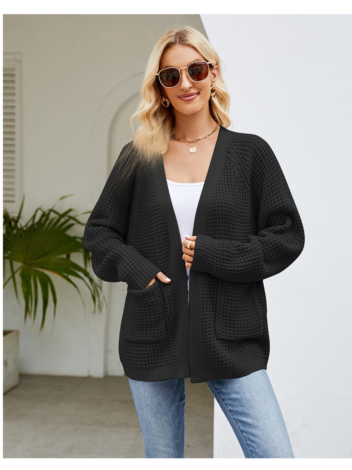 Black waffle knit cardigan with patch pockets and ribbed cuffs.