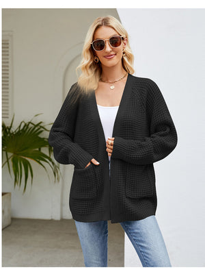 Black waffle knit cardigan with patch pockets and ribbed cuffs.
