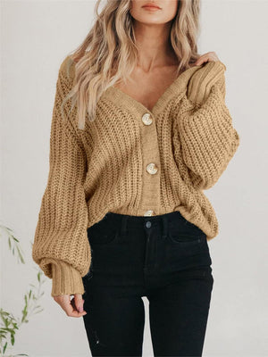Camel knit cardigan with voluminous sleeves and button front, styled with black jeans.