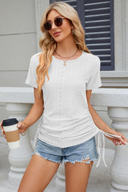 White perforated tee with gathered sides and drawstring detail.