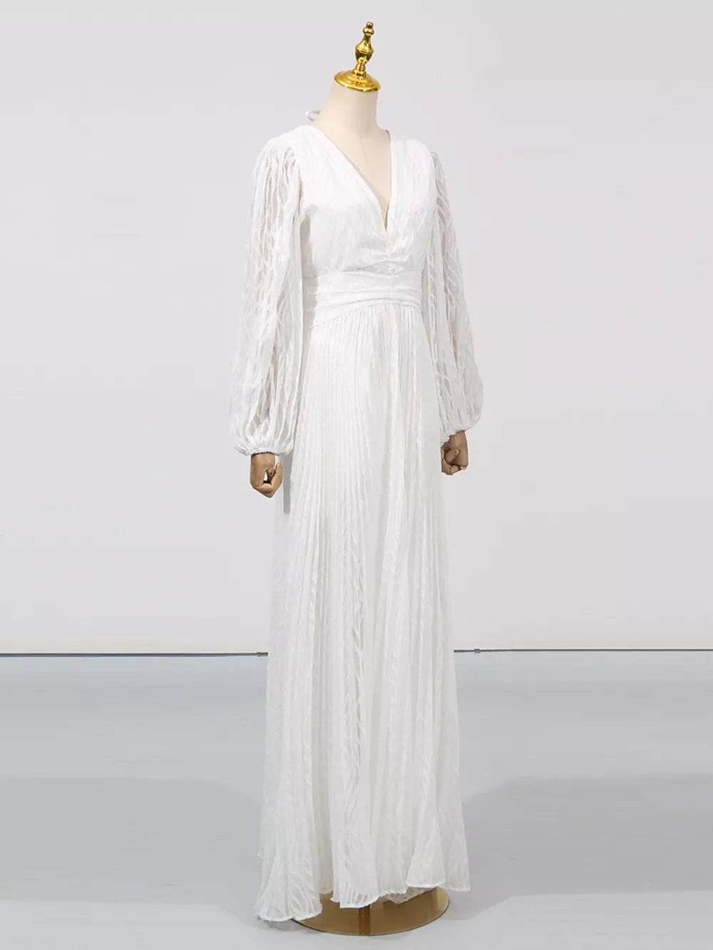 White maxi dress with V-neck, cinched waist, and voluminous balloon sleeves.