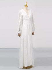 White maxi dress with V-neck, cinched waist, and voluminous balloon sleeves.