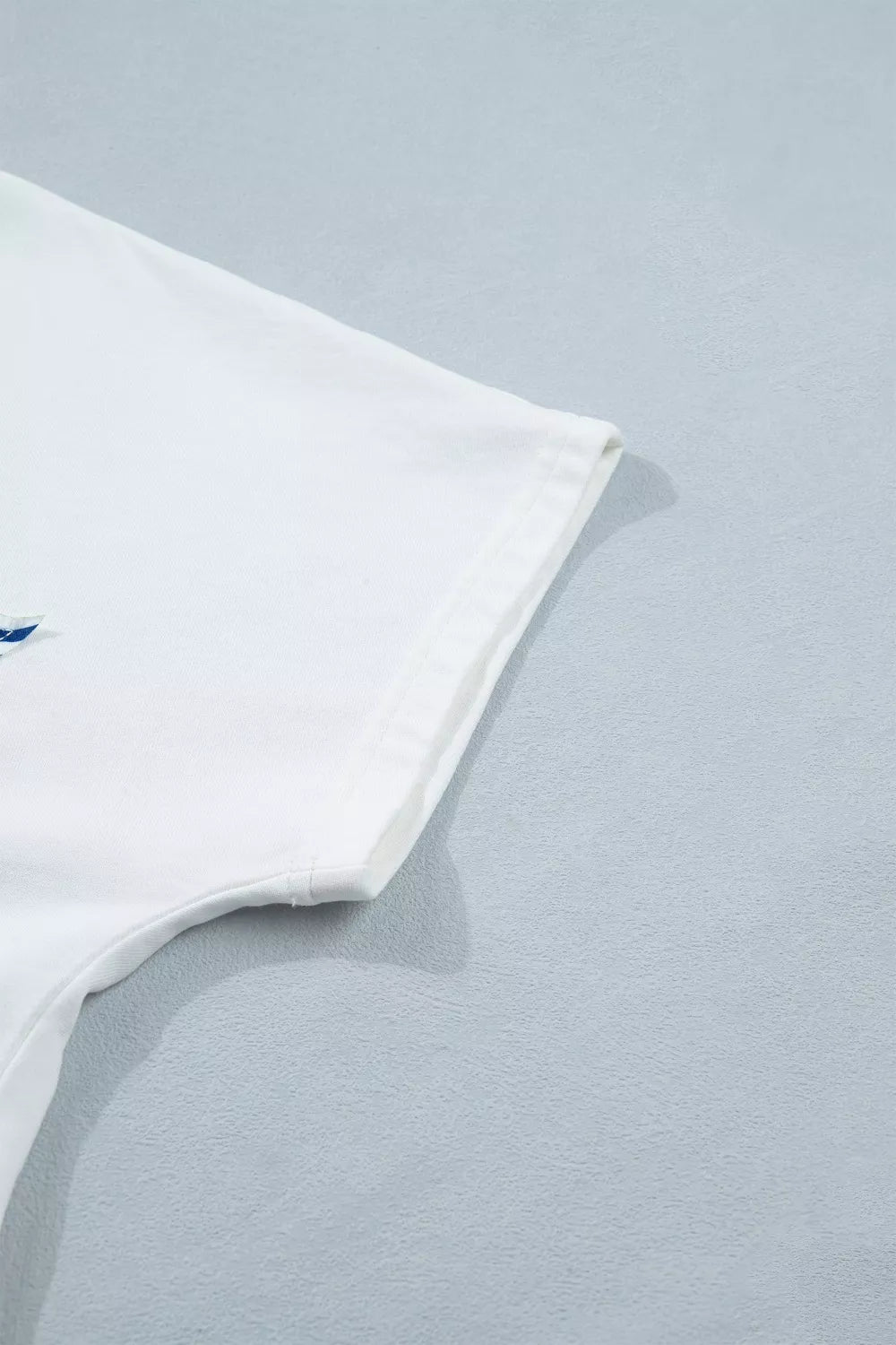 White cotton maternity tee with star applique and notched neckline detail.